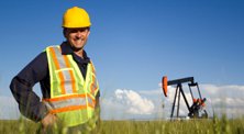 oil energy work man landman smiling man in construction work attire with blue open sky behind him